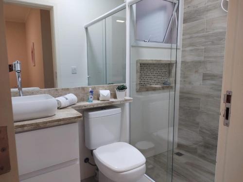 a bathroom with a toilet and a glass shower at Casa aconchegante no interior in Boituva