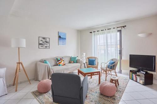 a living room with a couch and chairs and a tv at Ker Lys - Grande maison avec 4 chambres et jardin in Dinard