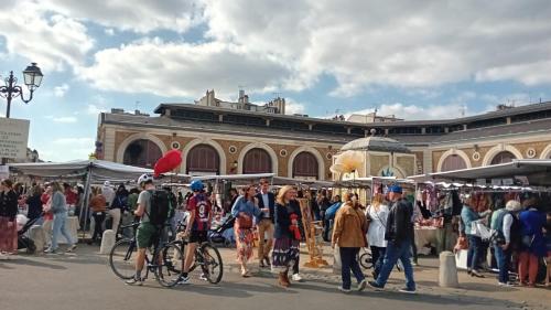 a group of people walking around a market with bikes at Appartement Le 5ème Ducis in Versailles