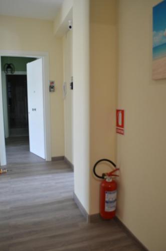 an empty hallway with a fire extinguisher in a room at Fondachello Suites - tra il vulcano e il Mar Ionio in Mascali