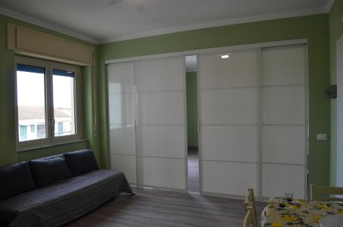a living room with a couch and a glass door at Fondachello Suites - tra il vulcano e il Mar Ionio in Mascali