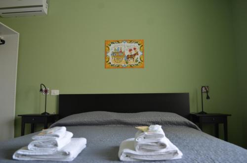 a bed with towels sitting on top of it at Fondachello Suites - tra il vulcano e il Mar Ionio in Mascali
