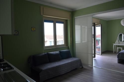 a living room with a couch and a window at Fondachello Suites - tra il vulcano e il Mar Ionio in Mascali
