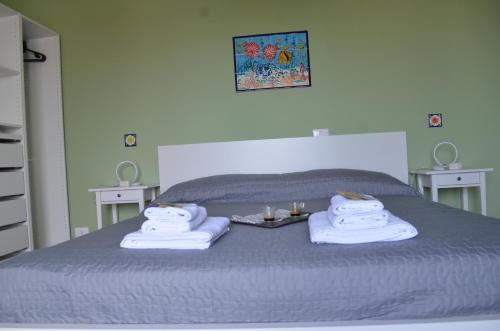 a bed with towels and a tray of food on it at Fondachello Suites - tra il vulcano e il Mar Ionio in Mascali