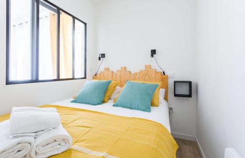 - une chambre avec un lit doté d'oreillers jaunes et bleus dans l'établissement L'Ivoire - Joli appartement - 1 chambre avec, à Rennes