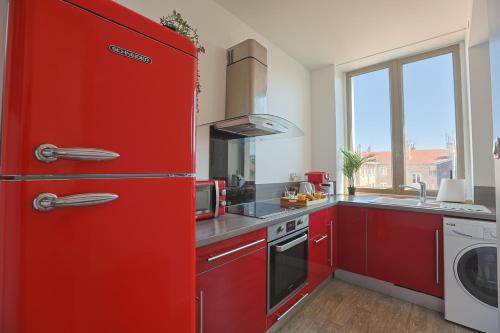 - un réfrigérateur rouge dans la cuisine avec évier dans l'établissement La Manufacture Cosy, à Saint-Étienne