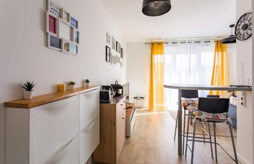- une cuisine avec un comptoir et une table dans une pièce dans l'établissement L'Ivoire - Joli appartement - 1 chambre avec, à Rennes