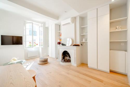Elle comprend un salon doté de murs blancs et d'une cheminée. dans l'établissement Petit Gambetta l Bright & Fresh l Shellter Rentals, à Saint-Tropez