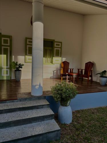 a house with a porch with chairs and a table at Chathra Rajgama in Rathgama