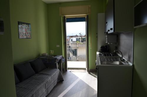 a living room with a couch and a kitchen at Fondachello Suites - tra il vulcano e il Mar Ionio in Mascali