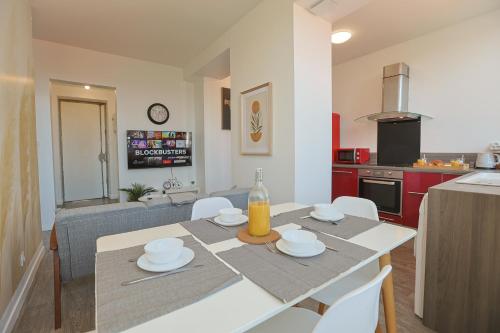 une cuisine et un salon avec une table et des chaises dans l'établissement La Manufacture Cosy, à Saint-Étienne