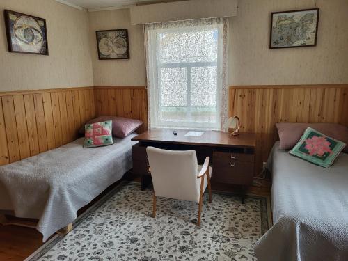 a room with two beds and a desk and a window at Agda's Garden in Sulkava