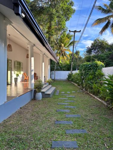 a garden with stepping stones in front of a house at Chathra Rajgama in Rathgama