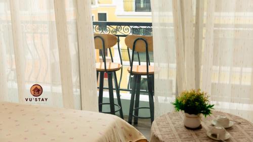 a room with a bed and two stools on a balcony at Vu'Stay in Binh Hai