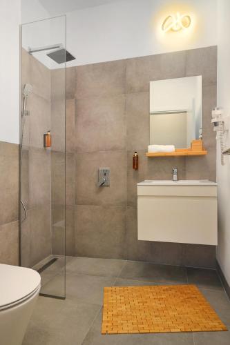 a bathroom with a shower and a toilet and a sink at Silk District Apartments in Iaşi