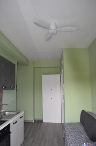 a living room with a ceiling fan and a door at Fondachello Suites - tra il vulcano e il Mar Ionio in Mascali