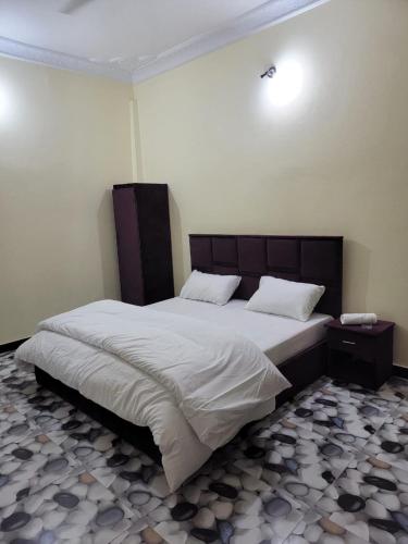 a bedroom with a large bed with white sheets at Galaxy Hotel Kalam in Kalām