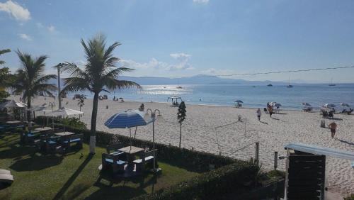 a beach with palm trees and people on the beach at Hotel Sete Ilhas in Florianópolis