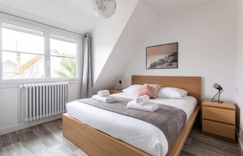 une chambre avec un lit avec deux serviettes dessus dans l'établissement Les Amarres - Maison familiale 3 chambres - Jardin, à Saint-Malo