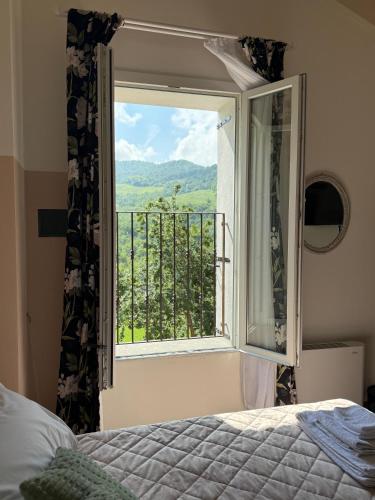 a bedroom with a bed and a window with a view at La Valle degli Amici in Pianello Val Tidone