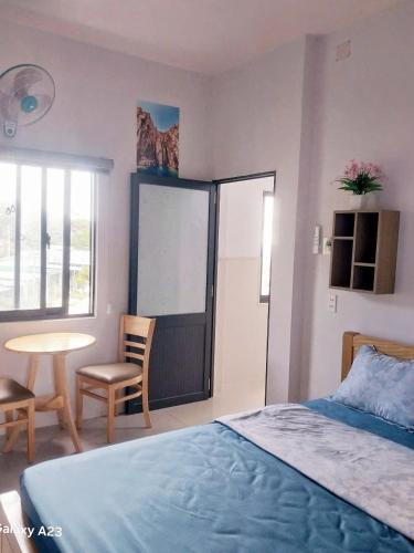 a bedroom with a bed and a table and a chair at Homestay TIẾN THÀNH in Ninh Hải