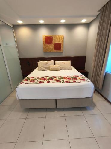 a bedroom with a large bed with flowers on it at Hotel Sete Ilhas in Florianópolis