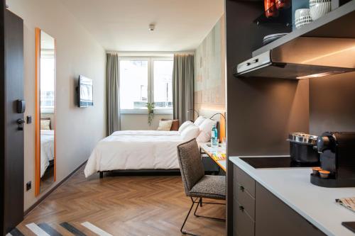 a small hotel room with a bed and a kitchen at LOGINN Hotel Offenbach in Offenbach