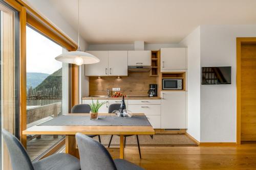 a kitchen and dining room with a table and chairs at Tratterhof Apt Astjoch in Vandoies