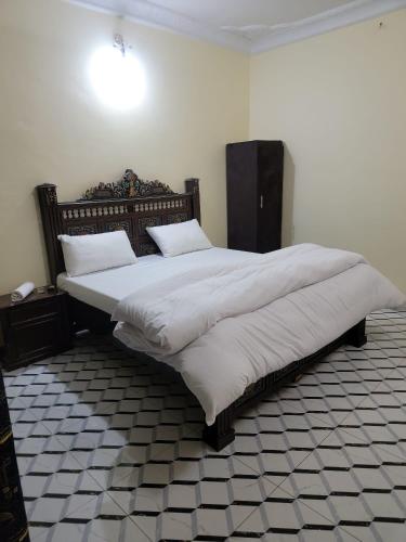a bedroom with a large bed with white sheets and pillows at Galaxy Hotel Kalam in Kalām