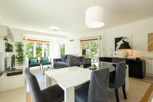 a dining room and living room with a table and chairs at Blue Beach by ACasaDasCasas in Ericeira