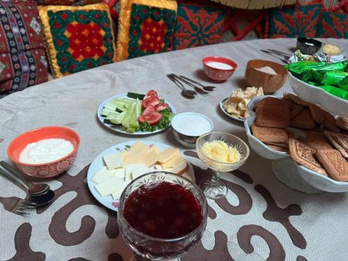 een tafel met borden met voedsel op een tafel bij Baytor Guest House in Karakol