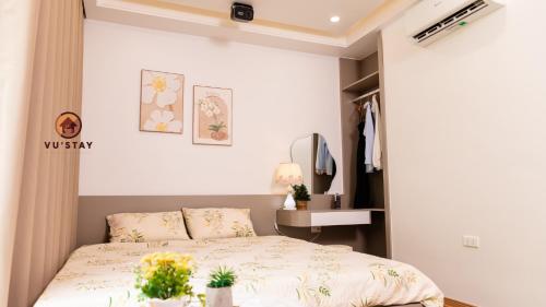 a bedroom with a bed and a table with flowers on it at Vu'Stay in Binh Hai