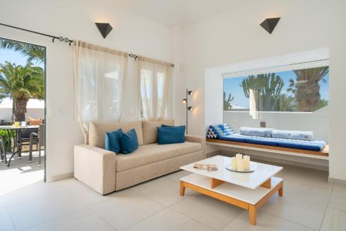 a living room with a couch and a table at Villa Irene Lanzarote en Costa Teguise en complejo con piscina comunal in Costa Teguise