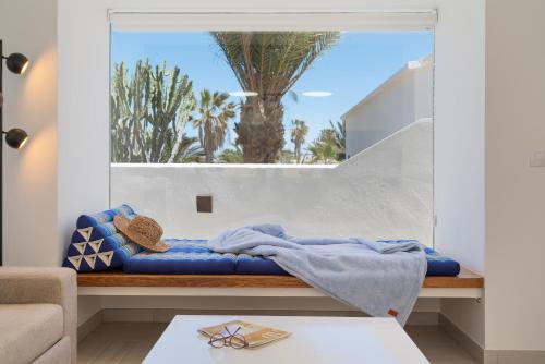 a room with a blue blanket on a bench with a window at Villa Irene Lanzarote en Costa Teguise en complejo con piscina comunal in Costa Teguise