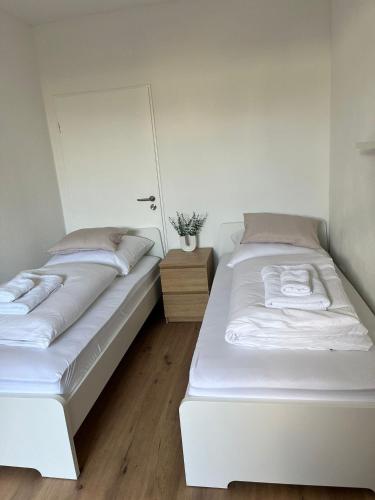 two beds in a white room with a mirror at Q Apartment No 3 in BS - stadtnah im Grünen wohnen in Braunschweig