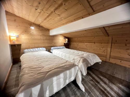 une chambre avec deux lits dans une cabane en rondins dans l'établissement Crepuscule 5 - Appartement proche pistes de ski et village, à La Clusaz