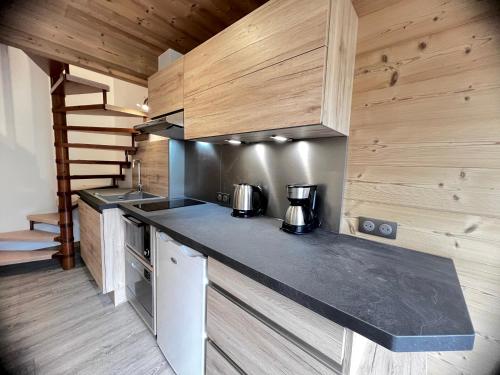 - une cuisine avec un comptoir et des murs en bois dans l'établissement Crepuscule 5 - Appartement proche pistes de ski et village, à La Clusaz