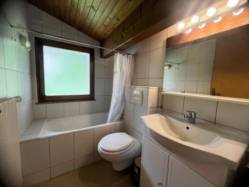 une salle de bain avec toilettes, baignoire et lavabo dans l'établissement Crepuscule 5 - Appartement proche pistes de ski et village, à La Clusaz