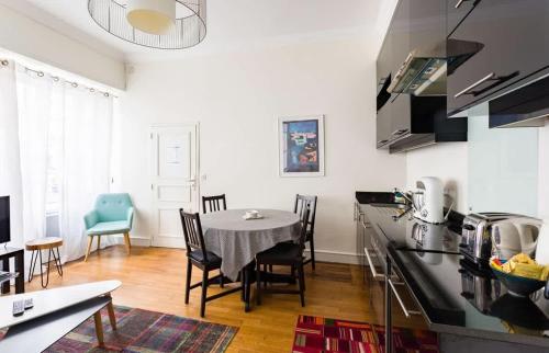 une cuisine et une salle à manger avec une table et des chaises dans l'établissement Le Chapitre - Appartement cosy, centre historique, à Rennes