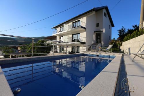 a house with a swimming pool in front of a building at Helvetia Apartments in Jajce