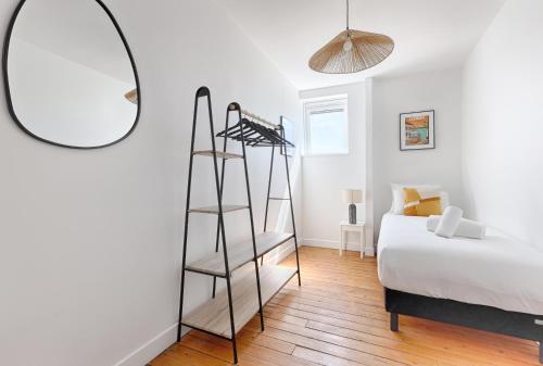 a bedroom with a ladder next to a bed and a mirror at Appartements à Champigny-Sur-Marne - 30 minutes de Disneyland in Champigny-sur-Marne