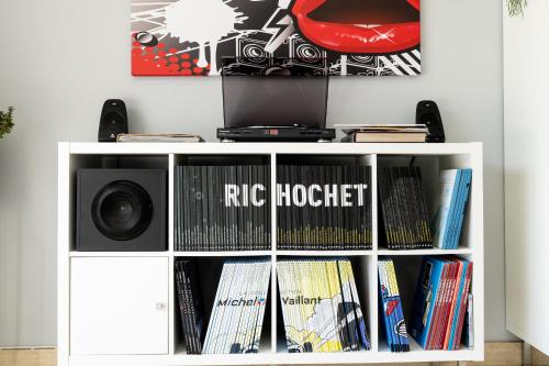 a white book shelf with books and a speaker at Kerwall - Maison d'hôtes in Malville
