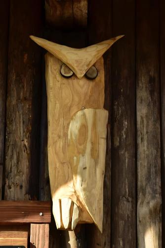 a wooden owl head with eyes on a wall at La rosa sul lago in Osiglia