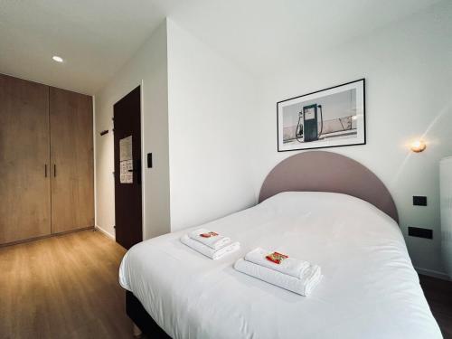 une chambre avec un lit blanc avec deux serviettes dessus dans l'établissement 602 Studio équipé à 2 pas du centre ville et gare, à Reims