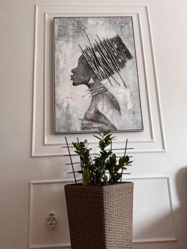 トレビニェにあるAFRIKAの植物のある部屋でギターを弾く女性の絵