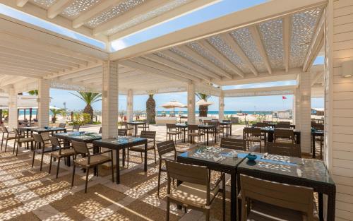a restaurant with tables and chairs on a patio at Steigenberger Marhaba Thalasso Hammamet in Hammamet