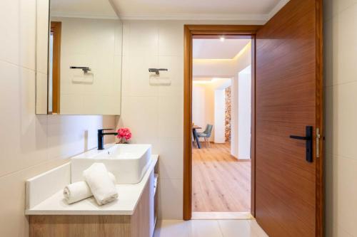 a bathroom with a white sink and a mirror at Venezia Luxury Living Villas, Faliraki in Faliraki