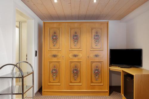 a wooden cabinet with a television in a room at Gasthaus Heiligenbrunnen in Titisee-Neustadt