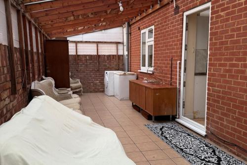 a brick room with a bathroom with a tub and a sink at 2 bed-Sleeps 4-Private Patio-Pets-Near Heathrow in Hounslow