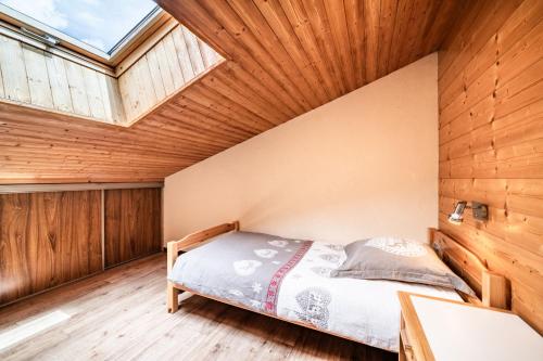 a bedroom with a bed and a skylight at La Flèche d'Or in Châtel